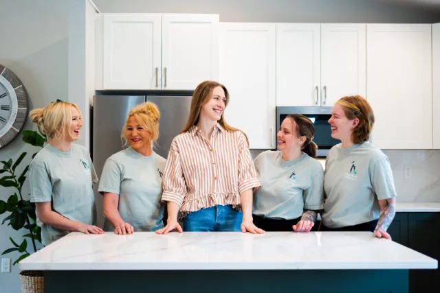 Happy at Home Cleaning team photographed together in a kitchen